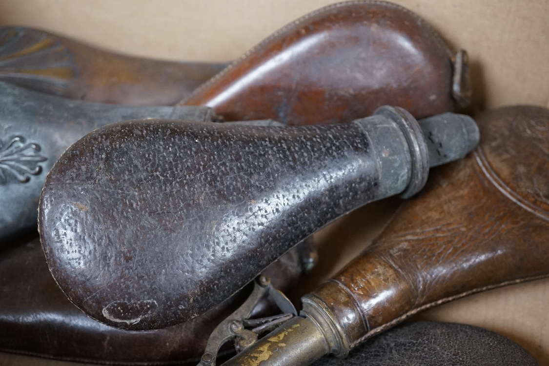 Three gun-sized copper powder flasks, two of which are embossed, together with four leather shot bags each with sprung chargers, two iron and two brass examples, one of which is embossed with a hunting scene (7)